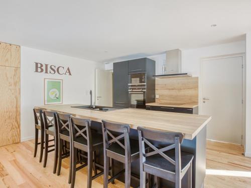 une cuisine avec une grande île entourée de chaises dans l'établissement Maison 3 étoiles, piscine chauffée, accès plage privée, 12 couchages, proche lac et forêt - FR-1-521-185, à Biscarrosse