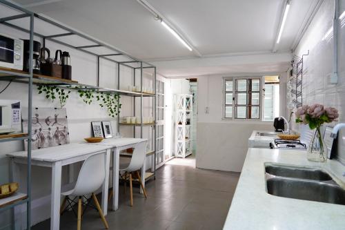 a kitchen with a sink and a counter with chairs at Hué Hostel in Punta Del Diablo