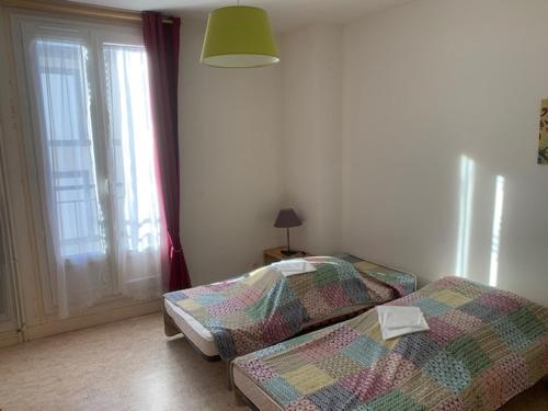 two twin beds in a room with a window at Appartement Mont-Dore, 2 pièces, 4 personnes - FR-1-415-129 in Le Mont-Dore