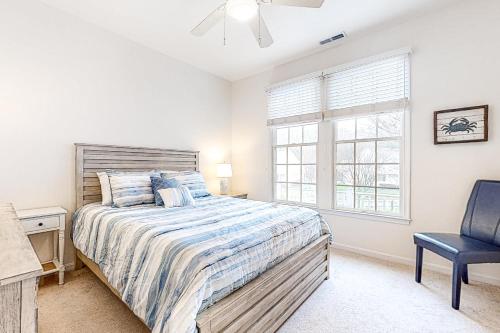Un dormitorio con una cama y una silla y una ventana. en Bear Trap Dunes - 210H October Glory Ave, en Ocean View