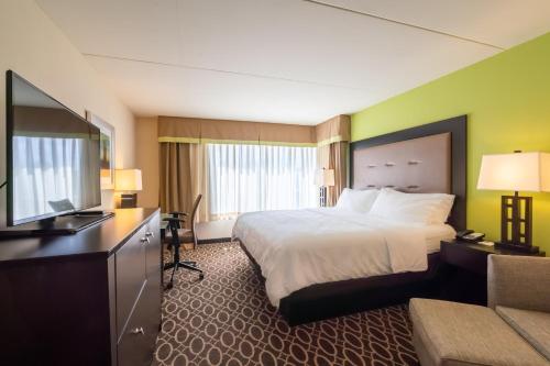 a hotel room with a bed and a flat screen tv at Holiday Inn Murfreesboro, an IHG Hotel in Murfreesboro