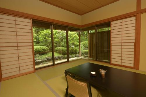 Pokój ze stołem, 2 krzesłami i oknami w obiekcie 熱海慧薗貸し切り w mieście Atami