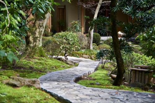 a stone path in a garden with a bench at 熱海慧薗貸し切り in Atami