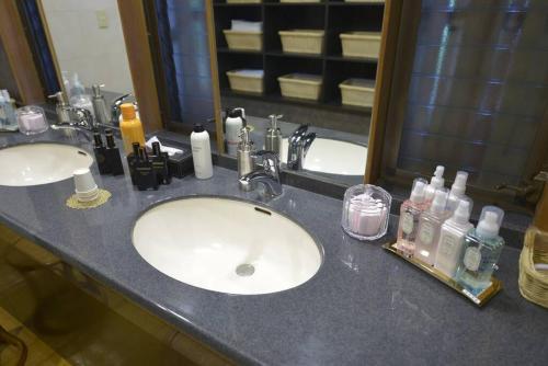 a bathroom counter with two sinks and a mirror at 熱海慧薗貸し切り in Atami