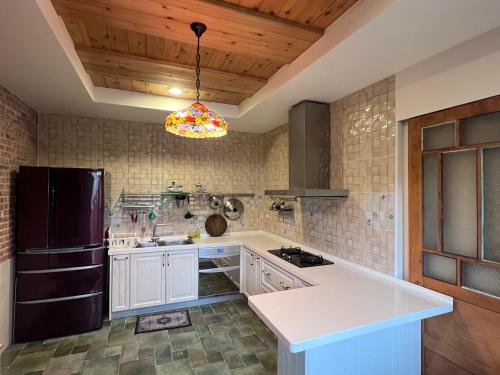 西湖鄉的住宿－馨藝庭園民宿，厨房配有白色橱柜和黑色冰箱。