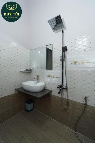 a bathroom with a sink and a mirror and a shower at Xuân Hải Complex-Hotel in Song Cau