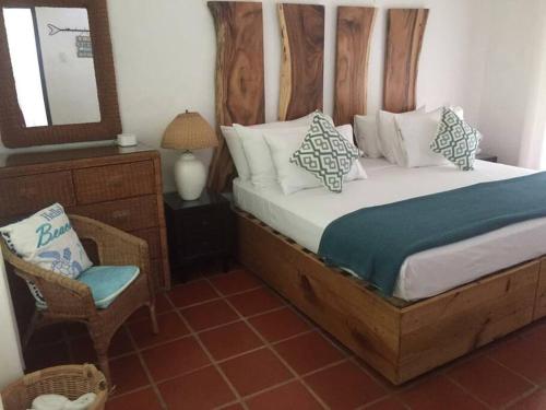 1 dormitorio con 1 cama con espejo y silla en Reefside Villa en Crown Point