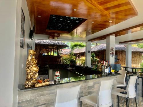 un bar in un resort con sedie bianche di GEM Crystal Water Resort a Davao