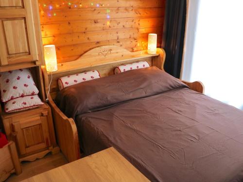 une chambre avec un lit et un mur en bois dans l'établissement Studio cosy entre pistes et sentiers – Parking inclus - FR-1-498-71, à Bernex