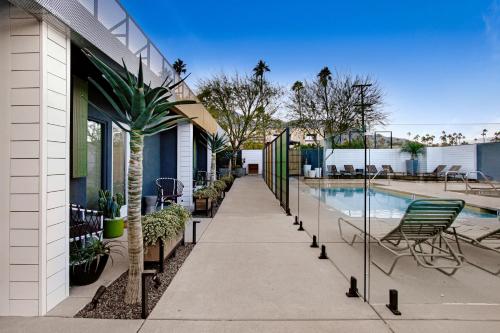 a walkway next to a house with a swimming pool at Mahala - 21 and Over - A Town & Desert Boutique Hotel in Palm Springs