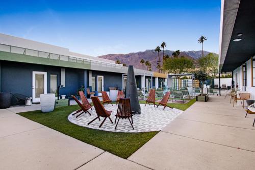 a group of chairs and umbrellas on a patio at Mahala - 21 and Over - A Town & Desert Boutique Hotel in Palm Springs