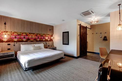 a bedroom with a large white bed and a desk at Mahala in Palm Springs
