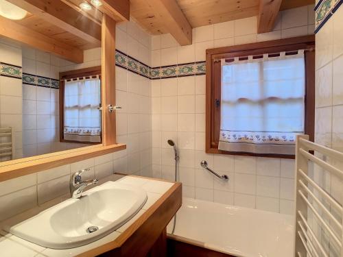 La salle de bains est pourvue d'un lavabo, d'une baignoire et d'une fenêtre. dans l'établissement Duplex 4 pièces avec parking et wifi au pied des pistes - FR-1-560-83, à Combloux