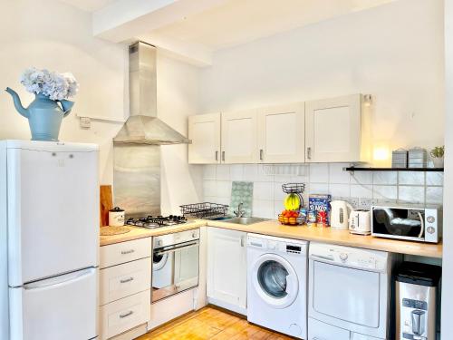a kitchen with a refrigerator and a washer and dryer at London Eye Centre Flat in London
