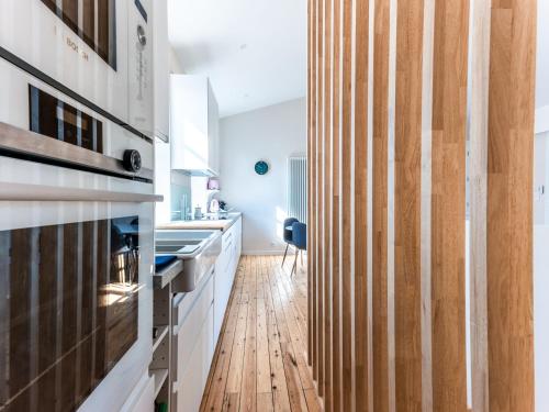 une cuisine avec des armoires blanches et un plancher en bois dans l'établissement Maison 3 ch. centre-ville, proche plage et marché, 8 pers, 3*, Wi-Fi - FR-1-197-523, à Les Sables-dʼOlonne
