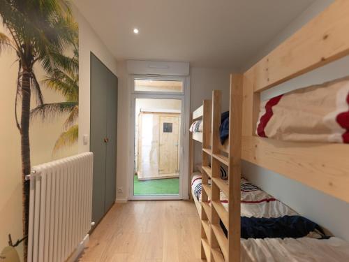 Cette chambre comprend 2 lits superposés et un palmier. dans l'établissement Maison 3 ch. centre-ville, proche plage et marché, 8 pers, 3*, Wi-Fi - FR-1-197-523, à Les Sables-dʼOlonne