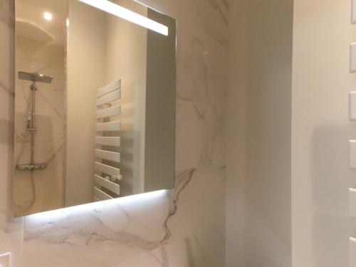 La salle de bains est pourvue d'un miroir et d'une douche. dans l'établissement Maison 3 ch. centre-ville, proche plage et marché, 8 pers, 3*, Wi-Fi - FR-1-197-523, à Les Sables-dʼOlonne