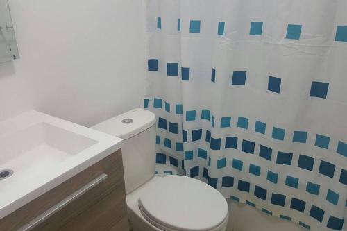 a bathroom with a white toilet and a sink at Tranquilidad Veraniega Pet Friendly in La Serena
