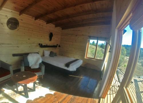 1 dormitorio en una cabaña de madera con 1 cama y 1 mesa en Fase a Tierra en 