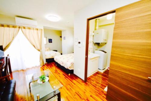 a room with a bedroom with a bed and a mirror at Chura Gahna House Tsubogawa Naha in Naha