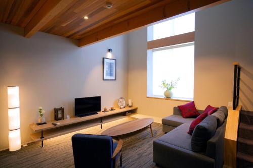 a living room with a couch and a tv at Hotel Sengokuhara 533 in Hakone