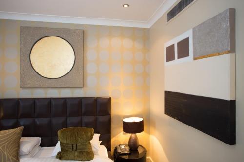 a bedroom with a bed with a black leather headboard at Washington Mayfair Hotel in London