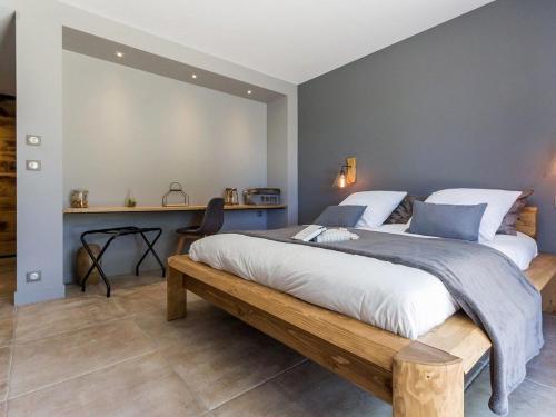 a bedroom with a large bed with a wooden bench at Villa Contemporaine avec Spa, Sauna, Piscine et Île Privative près de Nantes - FR-1-306-866 in Ligné