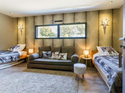 a living room with a couch and two beds at Villa Contemporaine avec Spa, Sauna, Piscine et Île Privative près de Nantes - FR-1-306-866 in Ligné