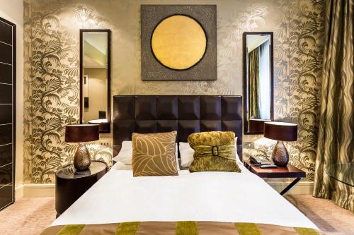 a bedroom with a bed and two lamps and a mirror at Washington Mayfair Hotel in London