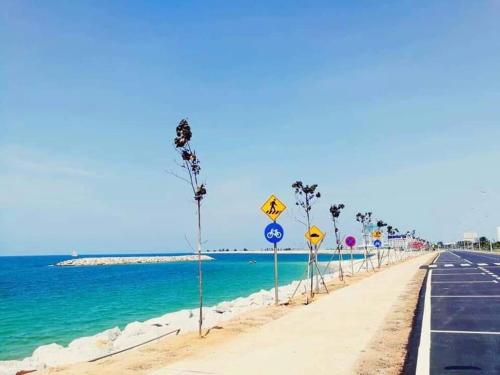 a road with signs on the side of the beach at AVA Homestay Kuala Terengganu Pantai Drawbridge in Kuala Terengganu