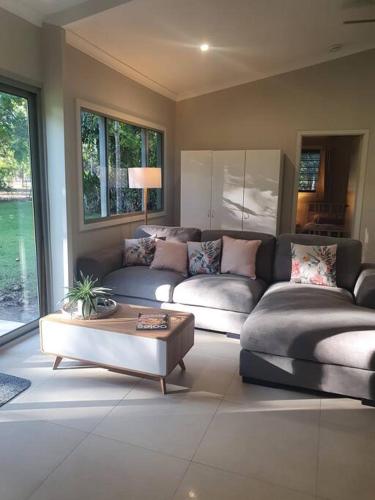 Sala de estar con 2 sofás y mesa de centro en Adorable 2 bedroom unit, set in lush gardens en McMinns Lagoon
