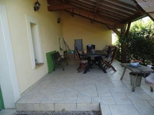 une terrasse avec une table, des chaises et une table en bois dans l'établissement Évasion rustique avec cheminée et vélos, proche du Mans - FR-1-410-166, à Congé-sur-Orne