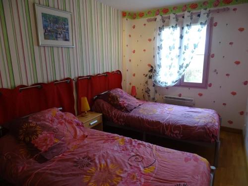 a bedroom with two beds and a window at Évasion rustique avec cheminée et vélos, proche du Mans - FR-1-410-166 in Congé-sur-Orne