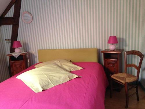 a bedroom with a pink bed with two tables and a chair at Gîte Yvré-l'Évêque, 3 pièces, 4 personnes - FR-1-410-194 in Yvré-lʼÉvêque