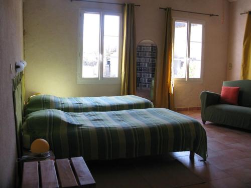 sypialnia z 2 łóżkami, kanapą i oknami w obiekcie Gîte Rouperroux-le-Coquet, 4 pièces, 6 personnes - FR-1-410-215 w mieście Rouperroux-le-Coquet