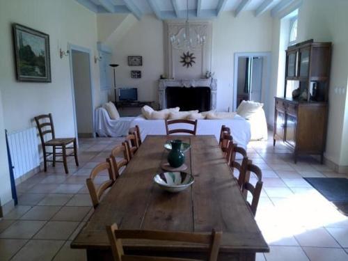 een woonkamer met een tafel en een bank bij Gîte Dureil, 6 pièces, 8 personnes - FR-1-410-208 in Dureil
