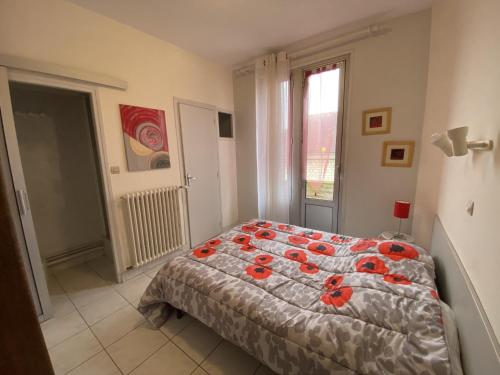 a bedroom with a bed with red flowers on it at Charmant T2 en Centre-ville avec Balcon et Wi-Fi proche des Thermes – La Roche-Posay - FR-1-541-77 in La Roche-Posay
