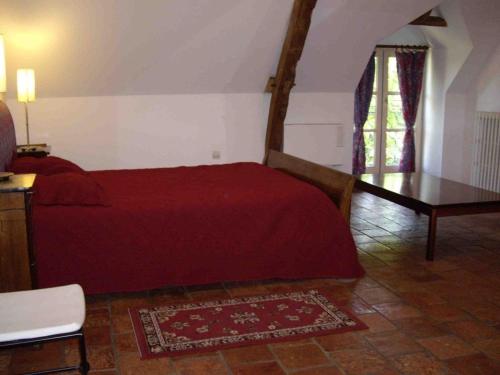 1 dormitorio con cama roja y mesa en Gîte Fontenay-sur-Vègre, 3 pièces, 4 personnes - FR-1-410-275, en Fontenay-sur-Vègre