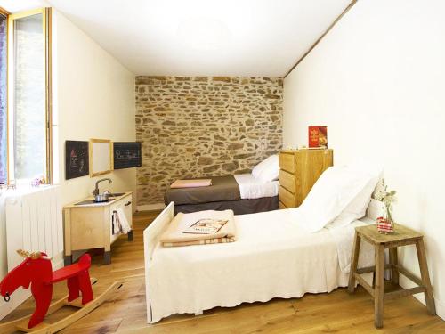 a bedroom with two beds and a stone wall at Gîte Badecon-le-Pin, 6 pièces, 11 personnes - FR-1-591-13 in Badecon-le-Pin