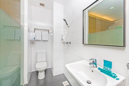 a bathroom with a sink and a toilet and a mirror at Hotel 81 Rochor in Singapore