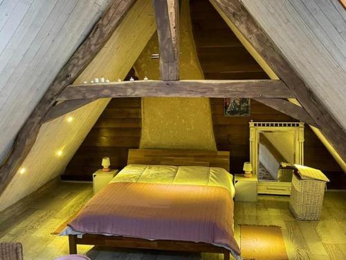 a bedroom in an attic with a bed in it at À louer : Ancienne forge avec sauna, piscine, proche plage et sites historiques - FR-1-591-193 in Le Menoux