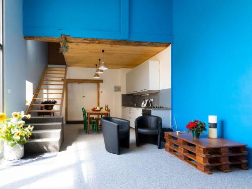 d'une cuisine et d'un salon avec un mur bleu. dans l'établissement Gîte familial près de Nancy avec grand jardin, spa, salle de jeux, et équipements pêche - FR-1-584-15, à Laneuveville-devant-Bayon