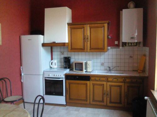 eine Küche mit Holzschränken und einem weißen Kühlschrank in der Unterkunft Gîte Futeau, 4 pièces, 6 personnes - FR-1-585-13 in Futeau