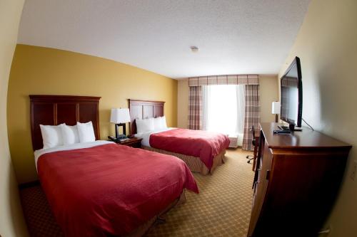 a hotel room with two beds and a window at Country Inn & Suites by Radisson, Macedonia, OH in Macedonia