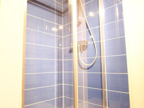 bagno con doccia e piastrelle blu di Gîte Aurec-sur-Loire, 4 pièces, 6 personnes - FR-1-582-191 a Aurec-sur-Loire