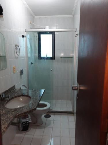 La salle de bains est pourvue d'une douche, d'un lavabo et de toilettes. dans l'établissement Apto no melhor ponto da Enseada, à Guarujá