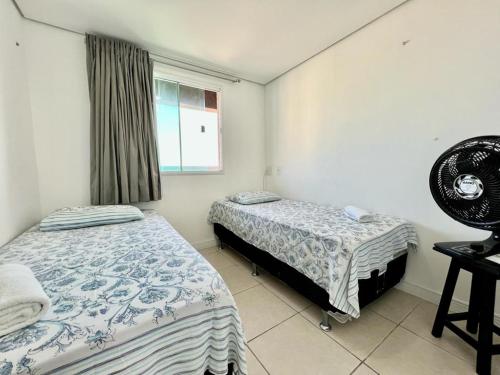 1 dormitorio con 2 camas y ventana en Duna Barcane Vista Mar Pontanegra Natal RN, en Natal