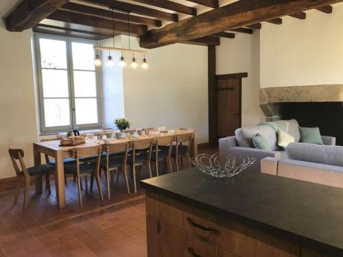 une cuisine et un salon avec une table et un canapé dans l'établissement Élégant gîte 18ème siècle rénové avec piscine couverte, terrasse et grand terrain aux Herbiers. - FR-1-426-406, aux Herbiers