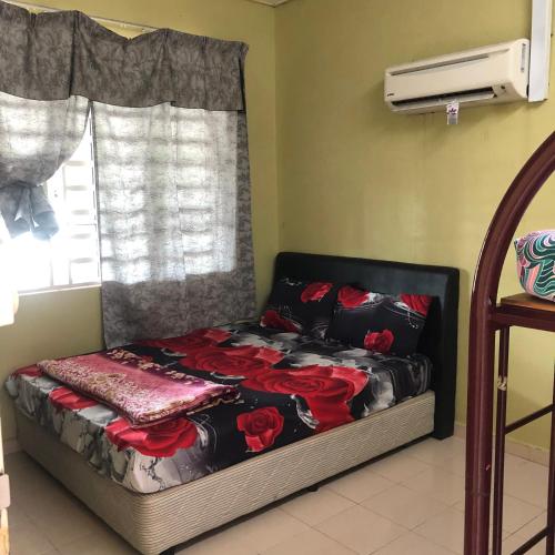 Bett in einem Zimmer mit Fenster in der Unterkunft ANGAH HOMESTAY LANGKAWI in Kuah