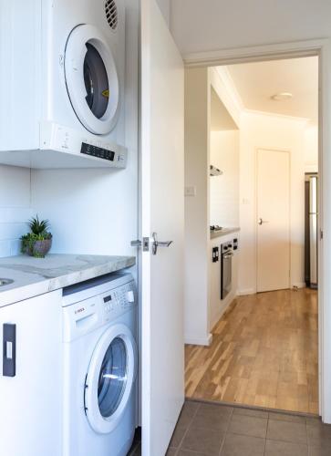 a white laundry room with a washer and dryer at Town Haus in Margaret River Town